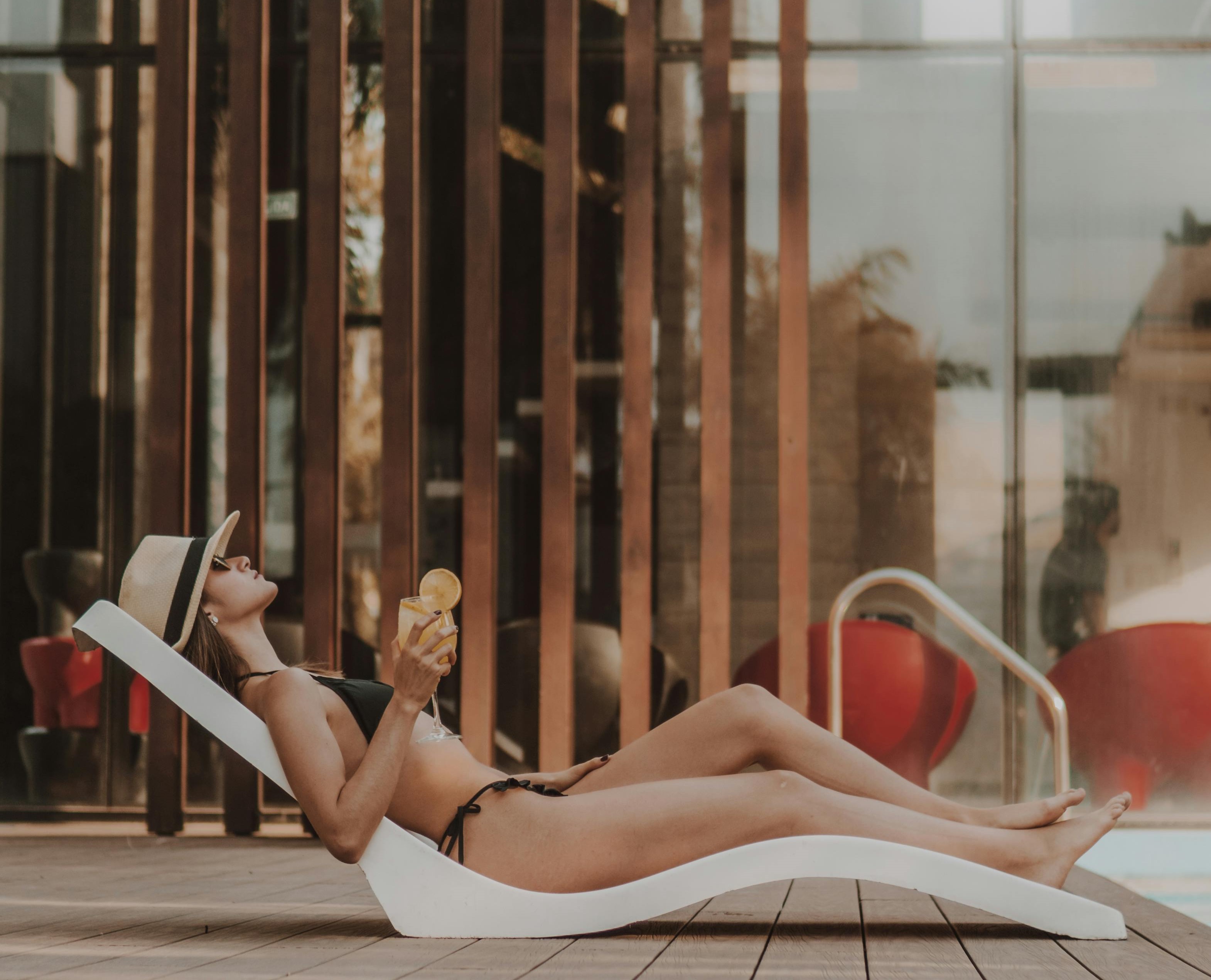 Vrouw op ligbed met cocktail