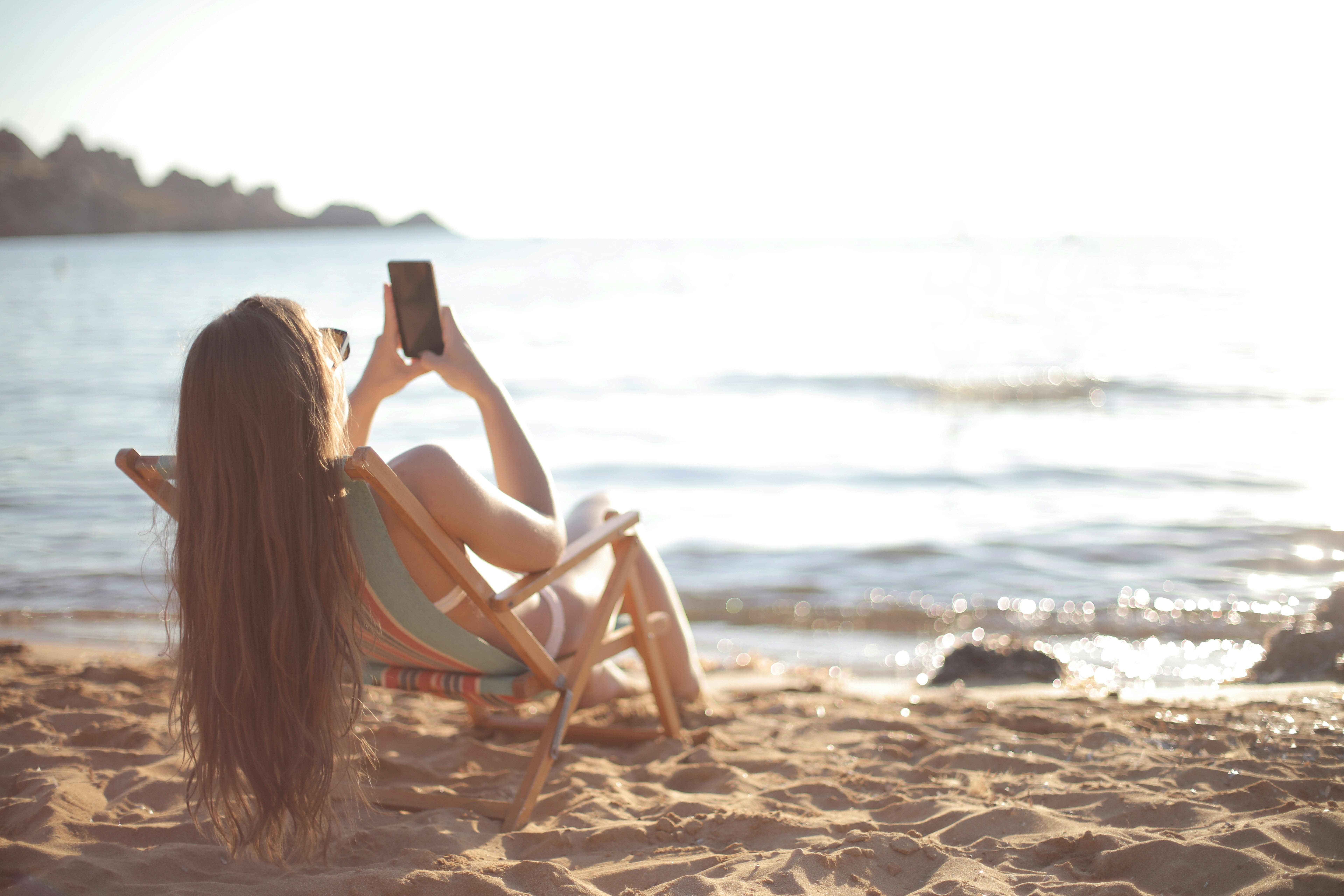 Vrouw op ligbedje op het strand